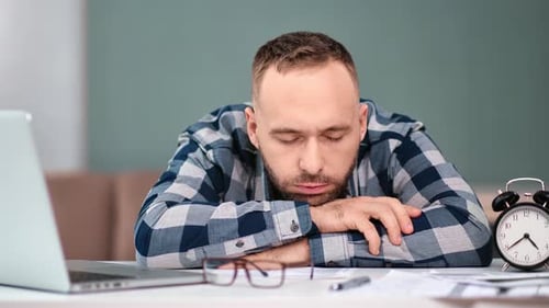 Tired Man Resting at Desk Overwhelmed by Work