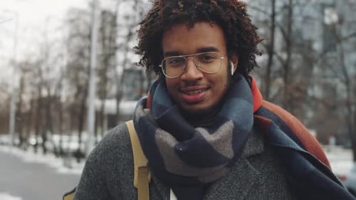 Young Man Walking on Urban Sidewalk