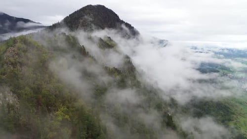Aerial View of Misty Mountainside With Rolling Clouds