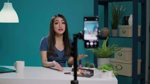 Mujer asiática filmando maquillaje tutorial con cámara de smartphone