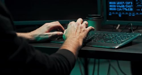 Um programador de computador ou hacker digita um código em um teclado de computador para invadir