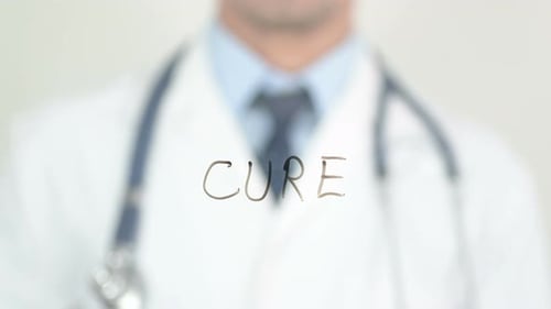 Doctor Writes The Word Cure on Glass