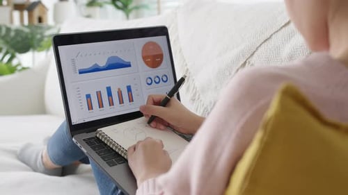 Junge asiatische Frau nutzt Computerarbeit und Fertigkeiten auf dem Heimsofa.