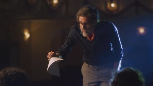 Man Presenting on Stage with Papers