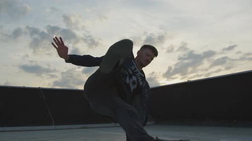 Young Man Performing Gymnastic Breakdancing Moves on Rooftop