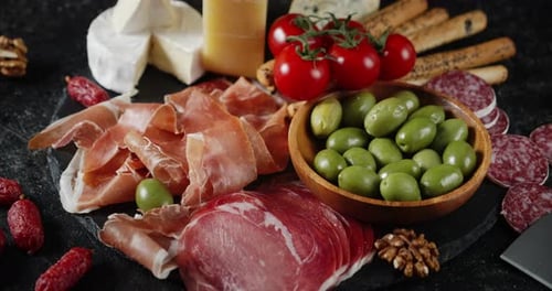 L'antipasto sur la planche de pierre tourne lentement.