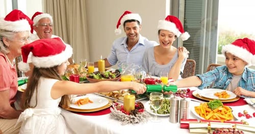 Family Celebrates Christmas with Crackers at Dinner Table
