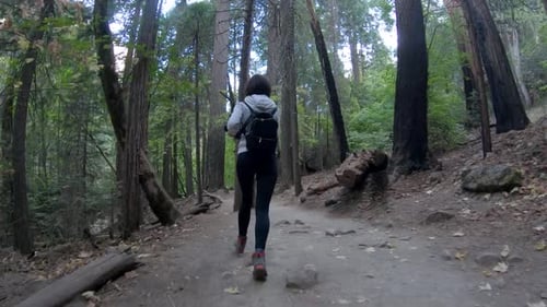 Young girl running in a forest at Yosemite National Park, USA