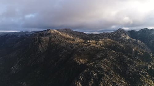 Aerial View of Rocky Mountains Under Cloudy Sky