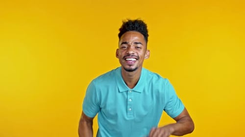 African Man Dancing Positive on Yellow Studio Background. Handsome Male Afro Black Model Guy. Party