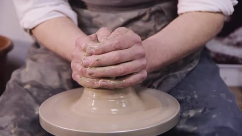 Les mains d'un potier fabriquent une cruche sur un volant de potier