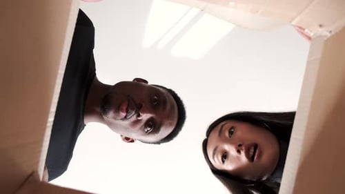 Diverse Couple Reacts with Surprise to Open Box