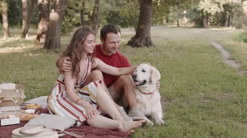 Happy Couple Enjoying a Picnic with their Dog