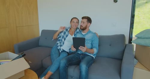 Young Couple Using Tablet in New Home