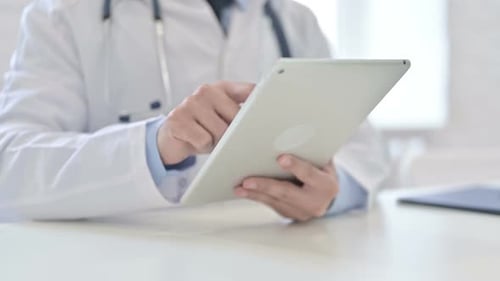 Close Up of Doctor Using Tablet