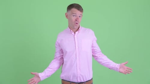Portrait of Confused Businessman Shrugging Shoulders