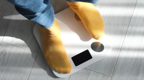 Feet in Socks Weighing on a Bathroom Scale