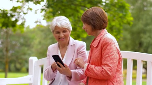 Happy Senior Women with Smartphone at Summer Park