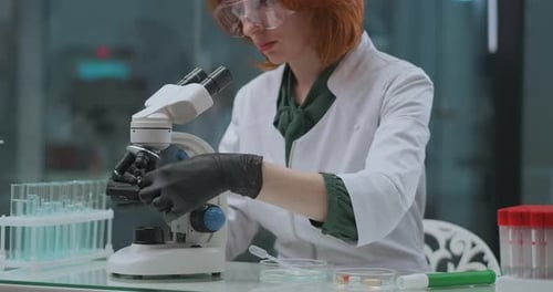 Female Scientist Using Microscope in Modern Lab