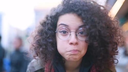 Slow motion close up young beautiful mixed race woman outdoor looking camera laughing