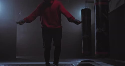 Closeup Athlete's Legs are Jumping Rope Dark Gym with Smoke