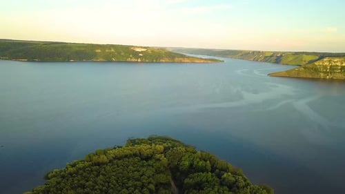 Aerial view of wide Dnister river and distant rocky hills in Bakota area, part of the National park