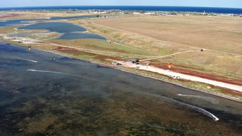 Sportsmen, people go in for kitesurfing on the sea. Top view of the kitesurfers.