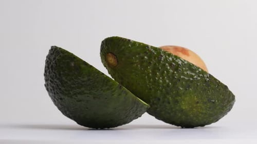 Fresh Avocado Half Rotating on White Background