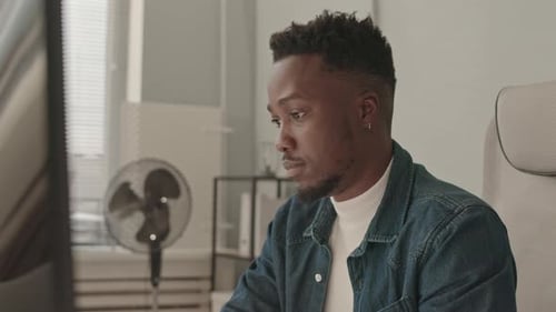 Young Man Working at Computer in Office