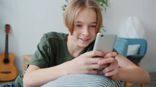 Teen Using Smartphone Device in Bright Home Setting