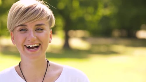 Portrait of Happy Young Woman in Summer Park