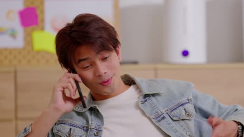 Young Man Talking on a Mobile Phone Indoors