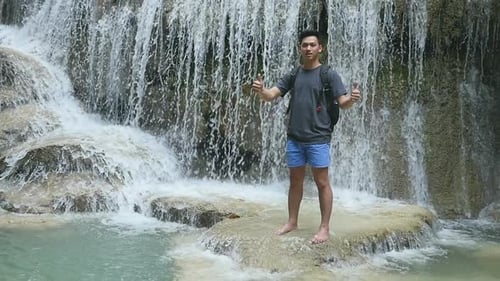 Man Posing Near Tropical Waterfall on Vacation