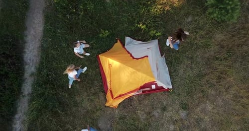 Children Run Around the Yellow Tent They are Resting Outdoors in the Woods