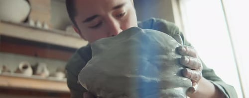 Young Sculptor Shaping Clay in Pottery Studio
