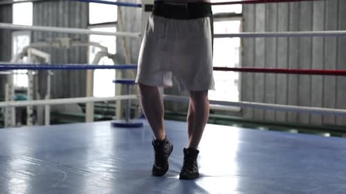 Man Exercising with Jump Rope in Boxing Ring