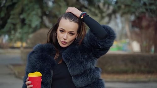 Elegant Woman Posing in Fur Coat with Coffee