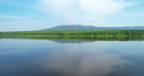 Die Wasseroberfläche des Sees mit einem Spiegelbild der farbenfrohen Landschaft