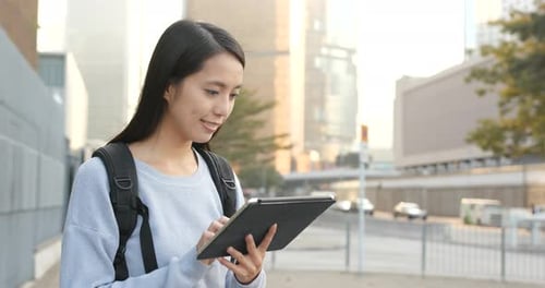 Woman Using Tablet on City Street