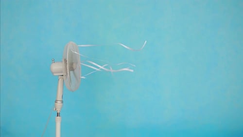 Ventilador eléctrico sobre fondo azul