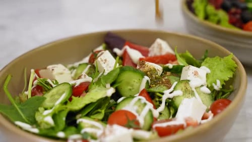 Colorful Salad With Vegetables and Feta Cheese Being Dressed
