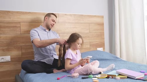 Father Braids Daughter's Hair in Bedroom
