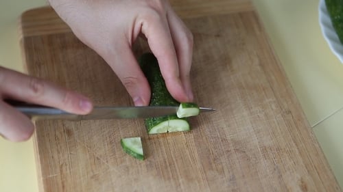 Cucumber Slicing on Wooden Cutting Board with Knife