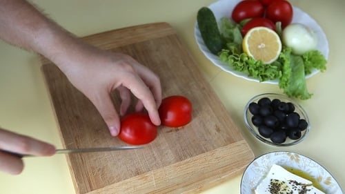 Hands Cutting Fresh Tomato on Cutting Board