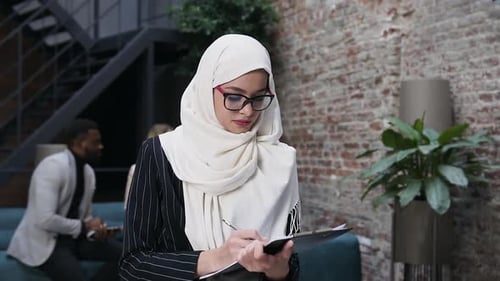 Woman Writing on Clipboard in Office Waiting Room
