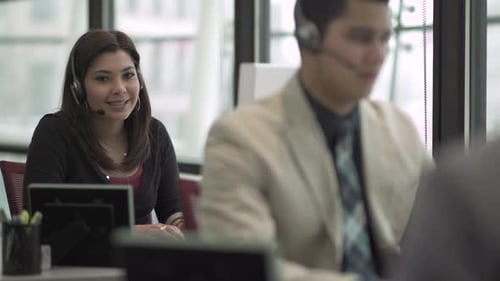 Eine Frau mit gemischter Rasse arbeitet in einem attraktiven modernen Call Center (2 von 6)
