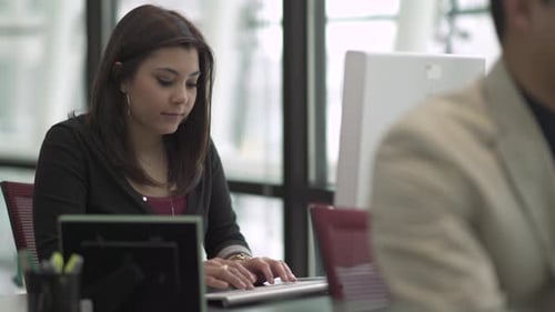 Eine Frau mit gemischter Rasse arbeitet in einem attraktiven modernen Büro (5 von 7)