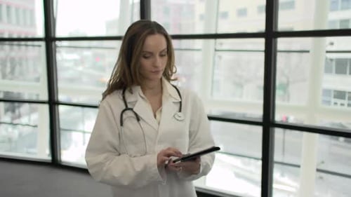 Female Doctor Holding Tablet in Modern Hospital