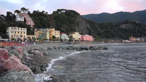 Waves on Rocky Beach near Colorful Coastal Town