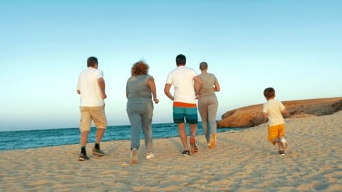 Familie rennt abends zum Meer